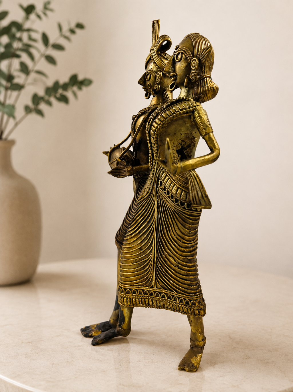 An ornate brass figurine of two dancing figures in traditional Indian attire